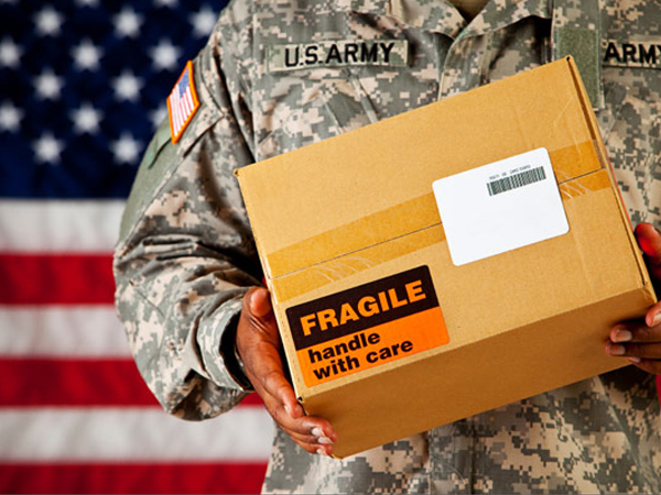 flag in background, military holding fragile box