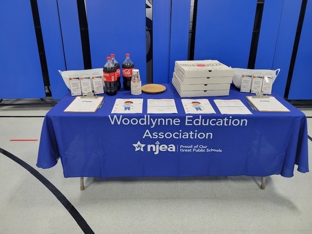 Woodlynne education association table with pizza soda crayons and pre k information flyers 