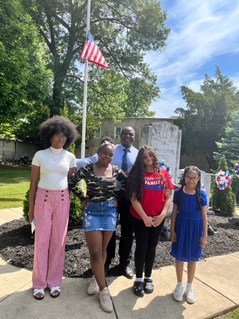 The Mayor with 4 students in front of American Flag