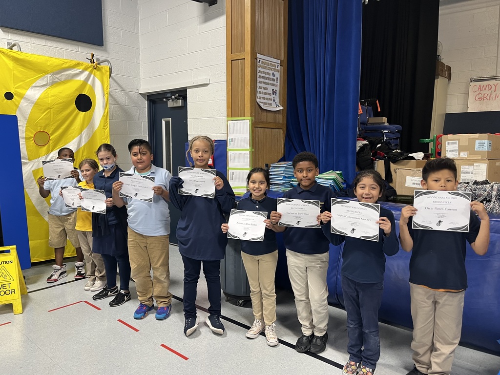 Students holding up honor roll certificates
